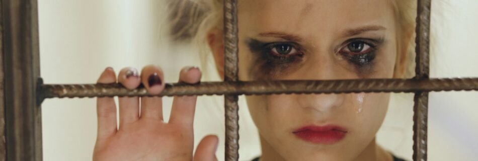 kurb tüdruk trellide taga, igatsemas oma vanemaid